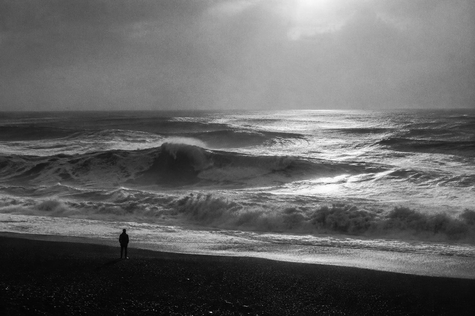 A solitary figure beside the ocean